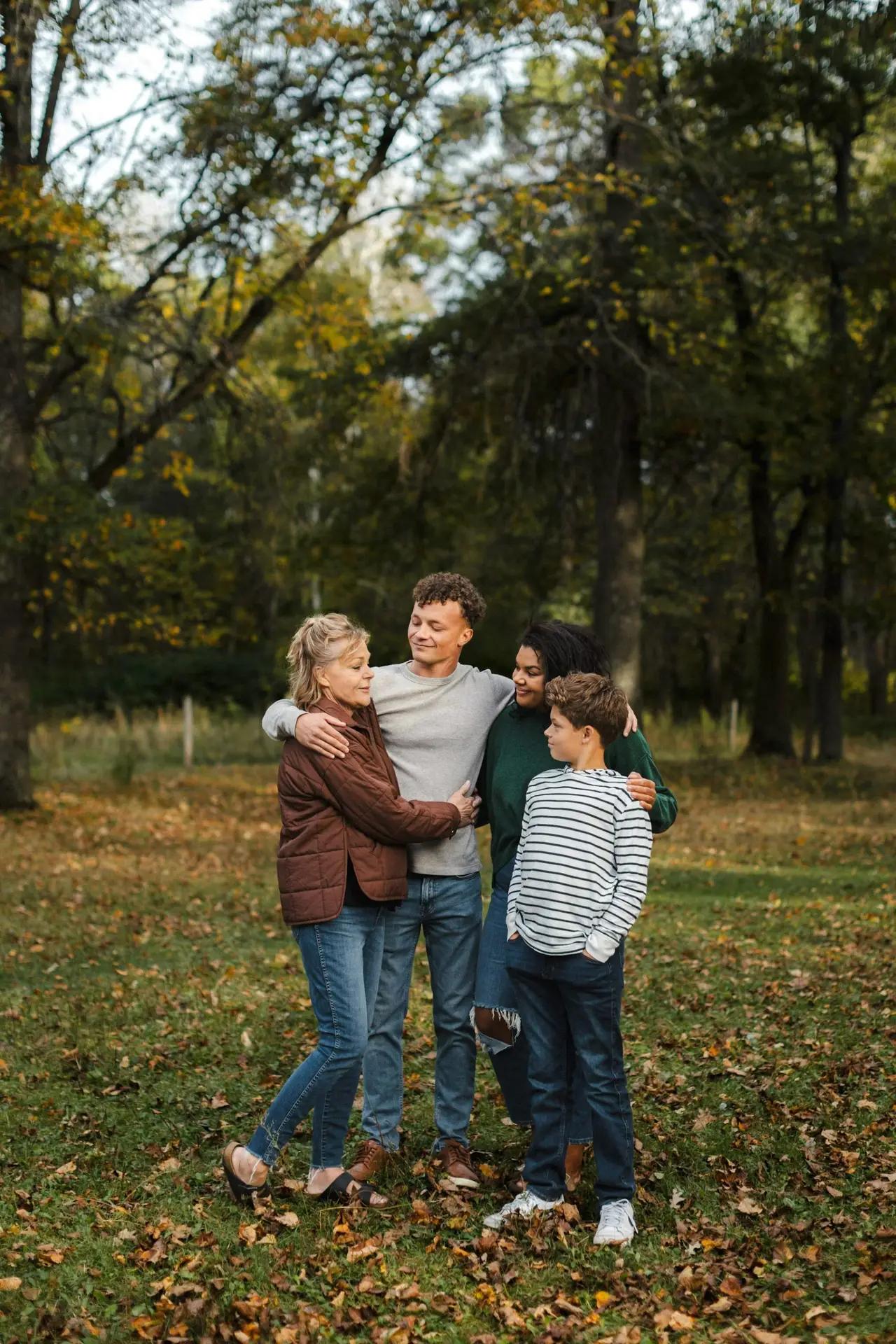Family standing together outdoors in a wooded setting