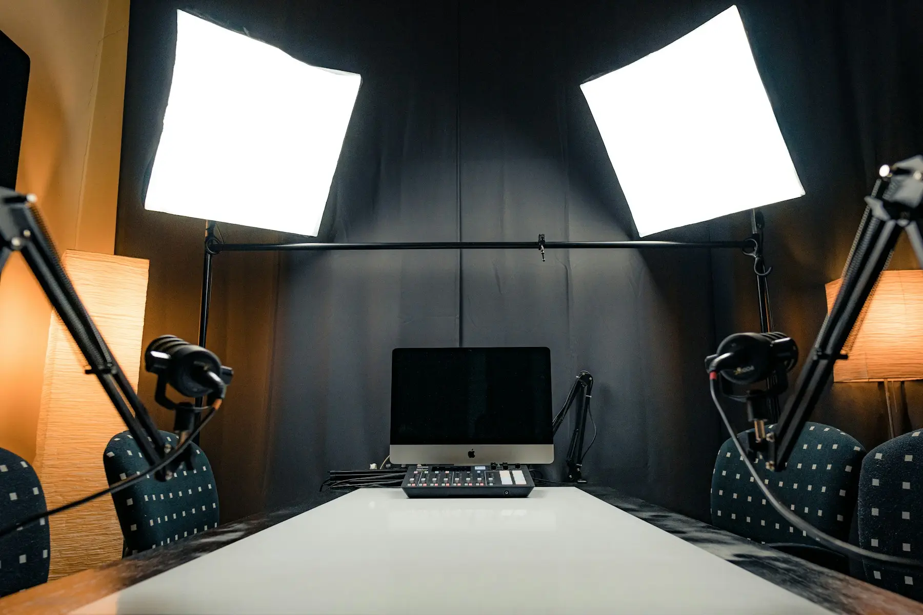 Podcast recording table with microphones, lighting, headphones and audio controls